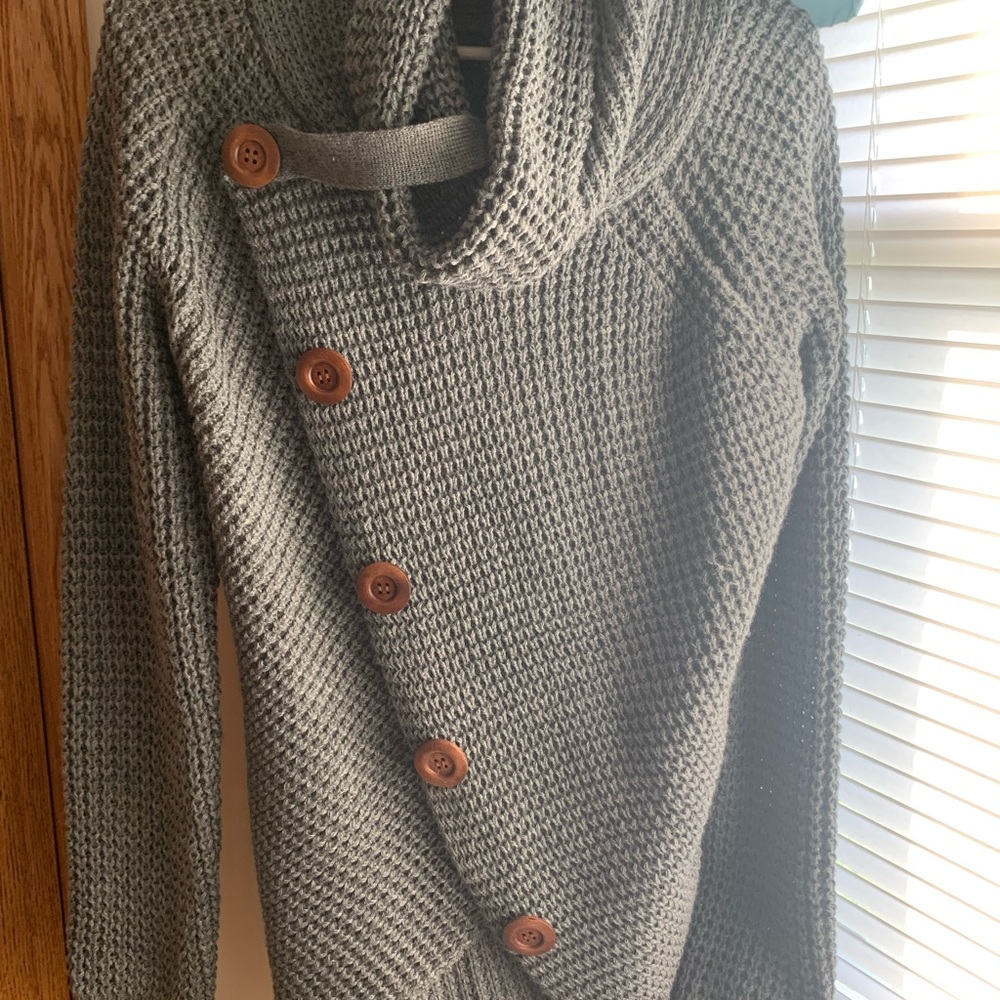 This sweater was purchased and never worn. It is a beautiful shade of gray